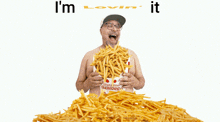 a shirtless man is holding a bag of french fries and the words i 'm lovin ' it are above him