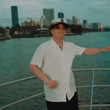 a man wearing a captain 's hat is standing on a boat in the water