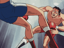 a man in a blue shorts is kicking another man in a red boxing glove