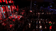 a crowd of people are gathered in front of a stage with coca cola written on it