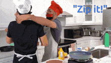 a man in a chef hat is hugging another man in a kitchen with the words " zip it " behind them
