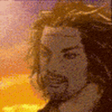 a man with long hair and a beard is standing in front of a sunset in a painting .