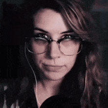 a close up of a woman wearing glasses and earphones .