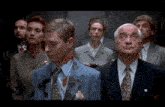 a group of people in suits and ties are standing in an elevator looking up