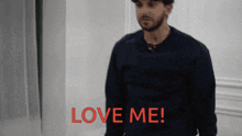 a man in a black shirt says love me in red