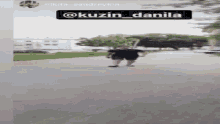 a man is walking down a sidewalk with a sign that says @kuzun danila