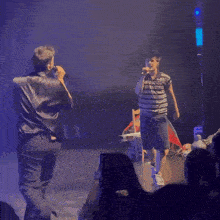 a man in a striped shirt is kissing another man on the forehead