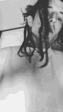 a black and white photo of a woman with dreadlocks taking a bath .