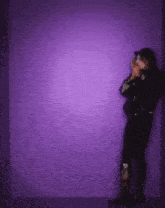 a person is standing in front of a purple wall