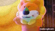 a stuffed animal with a lion 's head on it is standing in front of a screen .