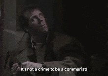 a man smoking a cigarette with the words it 's not a crime to be a communist