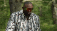 a man with a beard wearing sunglasses and a fur coat with eyes on it