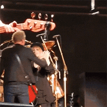 a man playing a guitar on a stage with a drummer