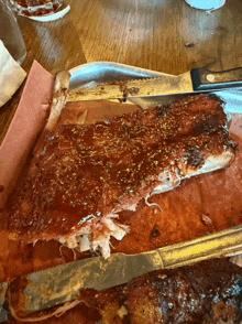a slice of ribs with a knife and fork on a table