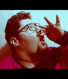 a man with glasses and a beard is blowing his nose