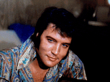 a close up of a man 's face with a shirt that says ' elvis presley ' on it