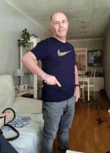 a man wearing a nike shirt is pointing to his waist
