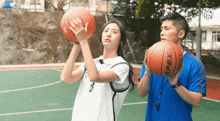 a man and a woman are playing basketball with an apex ball