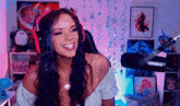 a woman wearing headphones is smiling in front of a shure microphone .