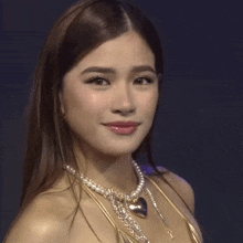 a woman with her eyes closed wearing a necklace with a heart pendant