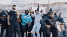 a group of people are dancing and one of them is wearing a blue jacket that says baby city