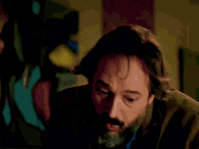 a woman in a green jacket is talking to a man in a blue shirt