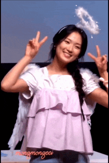 a girl with angel wings and a halo on her head is wearing a purple top