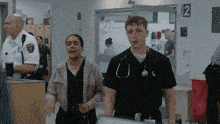 a man wearing a stethoscope is standing next to a woman wearing scrubs