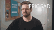a man wearing glasses and a black shirt is crying with the words epic sad below him