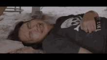 a woman is laying on the ground with her eyes closed and crying .