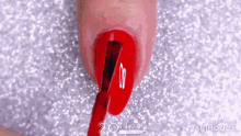 a close up of a person 's nail with red nail polish