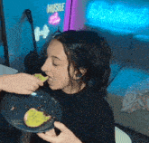 a woman eating a piece of food in front of a sign that says hustle