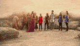 a group of people standing next to each other in a desert .