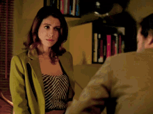 a woman in a green jacket stands next to a man in a tan jacket