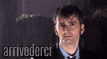 a man in a suit and tie is standing in the rain with the words arrivederci above him