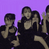 a group of people are sitting in front of a purple wall