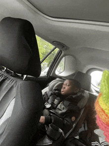 a child is sleeping in a car seat in the back