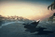a bird is flying over a body of water with a sunset in the background .