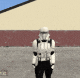 a storm trooper is standing in front of a building with the number 100 on the bottom right