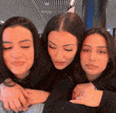 three women are posing for a picture with one wearing a ring on her finger