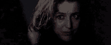 a close up of a woman 's face in the dark with a scared look on her face .