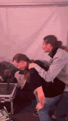 two women are standing next to each other and one is holding another woman 's back