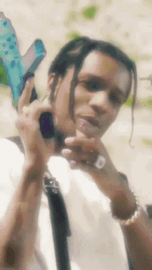 a close up of a man holding a gun with the letter d on his finger