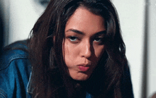 a woman in a denim jacket making a funny face