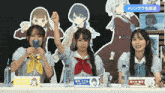 a group of girls sitting at a table with a sign that says # リンクラ 生放送 on it