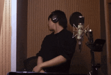 a man wearing headphones stands in front of a microphone that says yamaha on it