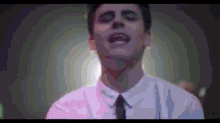 a man in a white shirt and tie is singing a song .
