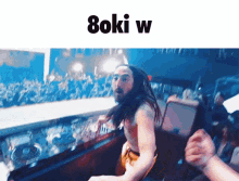 a man with long hair and a beard stands in front of a crowd with the words " boku w " written above him