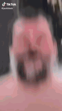 a blurred image of a man 's face with a tiktok logo on the bottom