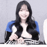 a girl with long hair is sitting at a table with the words soy de mari above her